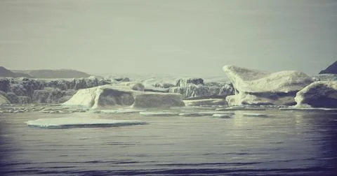 Icebergs float serenely in calm waters during a quiet morning in the Arctic Stock Illustration