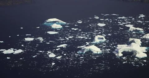 Icebergs float serenely in a vast ocean landscape at sunrise Stock Illustration
