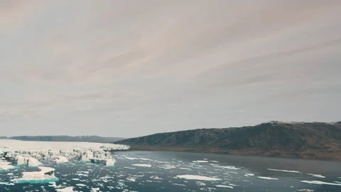 Icebergs float in water with mountains in the background near a glacier Stock Footage 343939941
