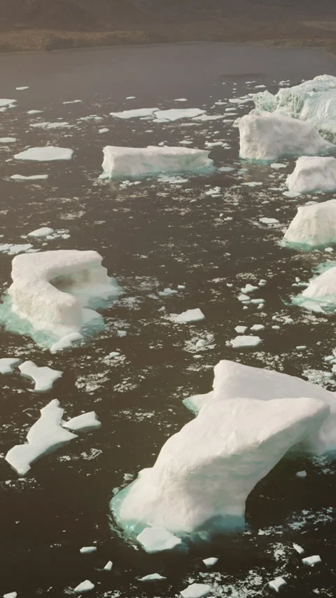 Icebergs float in the water under a clear sky in a remote location Stock Footage 340283942