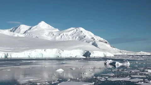 Icebergs floating in calm waters with bright blue skies over a polar landscape Stock-Footage 311651778