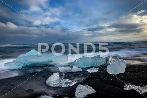 Icebergs floating in Jokulsarlon glacier lake at sunset in Icela Stock Photos