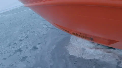Icebreaker nose on thin ice. Surface of ice broken by ship, splashes of water Stock Footage 229855369