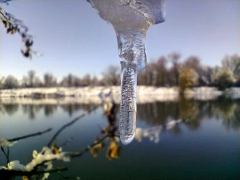 The icecicle with beatiful structure with the river in the background Stock Photos