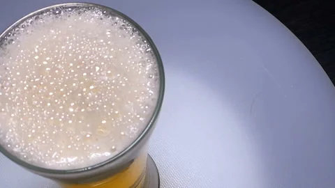 Icecube dropping into the beer with splash.Rotate and slow motion Stock-Footage 93011157