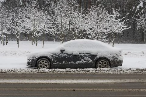 Iced and covered with a thick layer of snow car parked on the side of the r.. Stock Photos