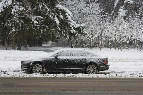 Iced and covered with a thick layer of snow car parked on the side of the r.. Stock Photos