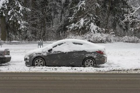 Iced and covered with a thick layer of snow cars parked on the side of the .. Stock Photos