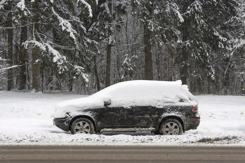 Iced and covered with a thick layer of snow car parked on the side of a for.. Stock Photos