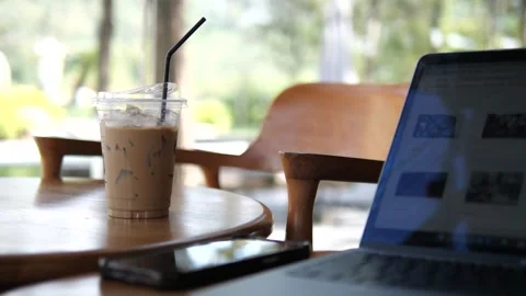 Iced Coffee on Cafe Table with Laptop in Modern Workspace Natural Light Stock Footage 325237353