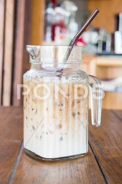 Iced coffee latte serving in glass pitcher Stock Photos