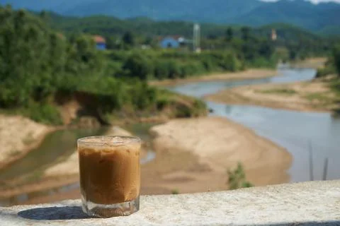 Iced coffee or caffe latte in front of a nice blurred landscape in Vietnam Stock Photos