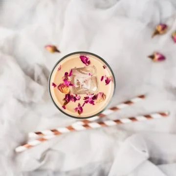 Iced coffee with rose and cardamom in a tall glass Stock Photos
