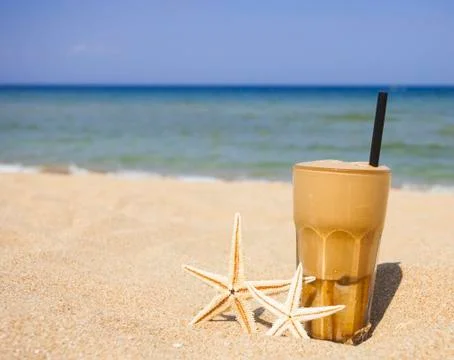 Iced coffee on a sandy beach background Stock Photos