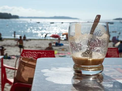 Iced coffee on a table by the beach Stock Photos