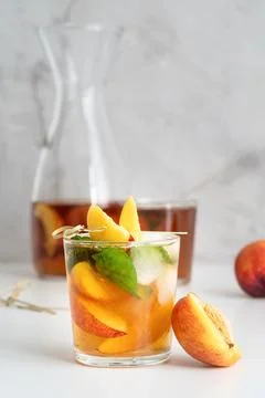 Iced cold peach tea with fruit slices and mint Stock Photos