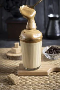 Iced Dalgona Coffee, a trendy fluffy creamy whipped coffee, on a dark wooden  Foto stock