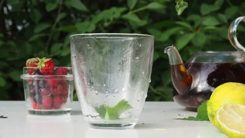 Iced fruit tea cold berry drink in clear glass mint leaf Refreshing summer drink 動画素材 168018906