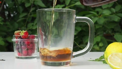 Iced fruit tea cold berry drink in clear glass mint leaf Refreshing summer drink 動画素材 168018907