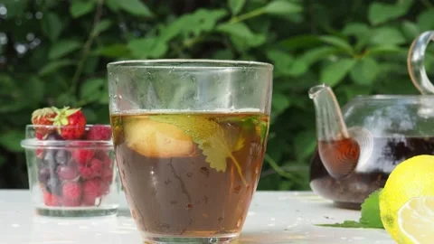 Iced fruit tea cold berry drink in clear glass mint leaf Refreshing summer drink Stock Footage 168018950