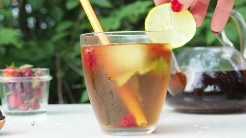 Iced fruit tea or cold berry drink in clear glass with mint leaf 動画素材 168018979