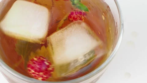 Iced fruit tea or cold berry drink in clear glass with mint leaf Stock Footage 168018996