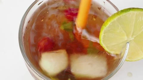 Iced fruit tea or cold berry drink in clear glass with mint leaf 動画素材 168018997