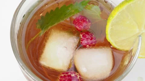 Iced fruit tea or cold berry drink in clear glass with mint leaf 動画素材 168019001