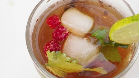 Iced fruit tea or cold berry drink in clear glass with mint leaf 動画素材 168019002