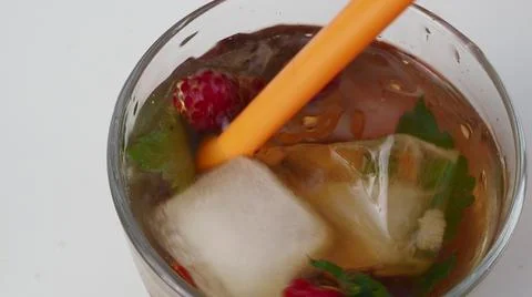 Iced fruit tea or cold berry drink in clear glass with mint leaf. fresh berri Stock Photos