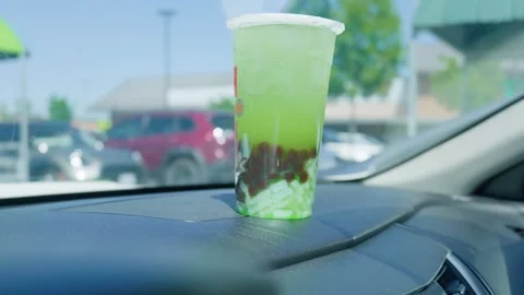 Iced green bubble tea with boba pearls on car dashboard 库存影片 338031659