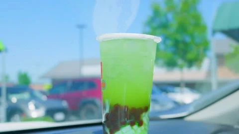 Iced green bubble tea with tapioca pearls on car dashboard 動画素材 338018589