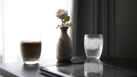 Iced latte coffee a white rose in a vase and a glass of cold water Video stock 333059611