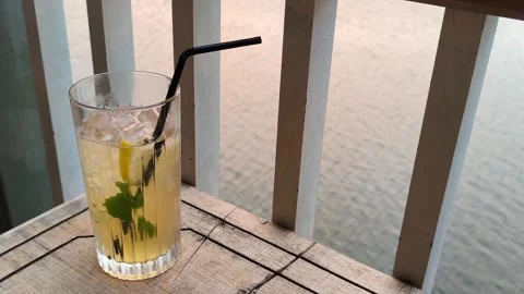 Iced Lemon Mint Tea Glass by Riverside at Sunset Real Time Video stock 339646580