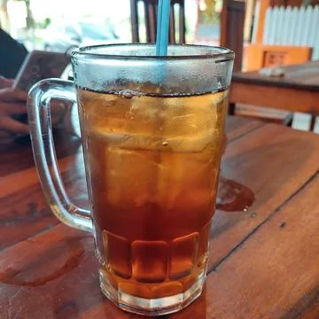Iced lemon tea with ice cubes in a large glass Stock Photos