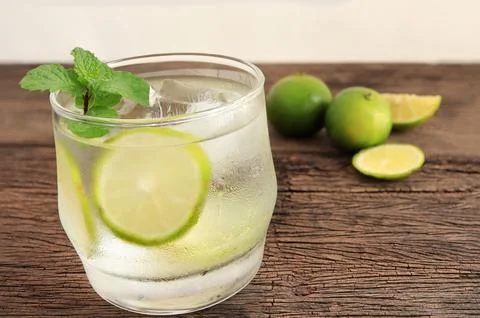 Iced lime with mint leaves on dark old wooden background.  Stock Photos