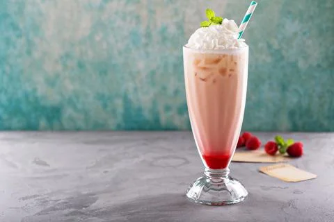 Iced milkshake with raspberry syrup and whipped cream Stock Photos