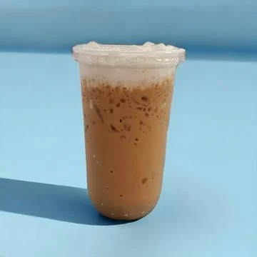 Iced tea in a clear plastic cup. Blue background with shadow Stock Photos