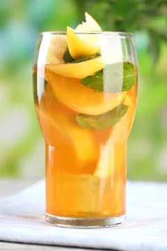 Iced tea with lemon and mint on wooden table, outdoors Stock Photos