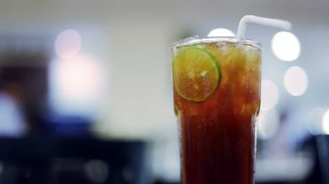 Iced tea with lime slice and blurred restaurant background Video stock 66692792
