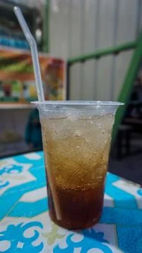 Iced Tea in Plastic Cup with Straw on Colorful Table 스톡 사진