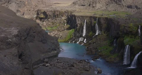 In Iceland drone arc shot captures waterfall from a rocky outcrop Stock Footage 286035890