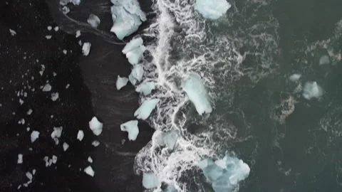 Iceland Drone Overhead shot of waves hitting ice at diamond beach 4K Video stock 242117656