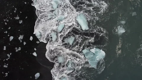Iceland Drone overhead of waves hitting icebergs at diamond beach 4K Video stock 242117723