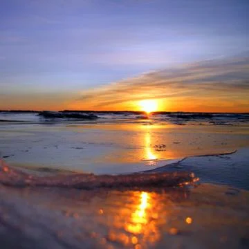 Iceland, Surface level view of sunset over water covered with ice crust Stock Photos