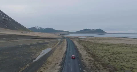 Iceland, Tracking Drone Shot of Red Car Moving on Ring Road Between Stock Footage 245248792