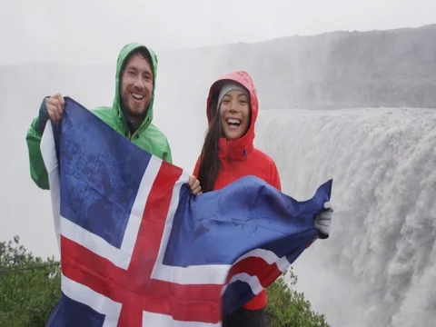 Iceland travel tourists by Dettifoss waterfall on Iceland showing Icelandic flag Stock Footage