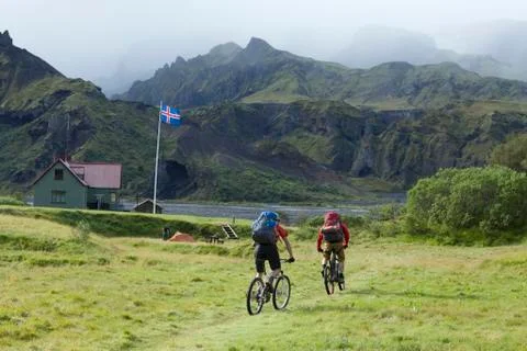 Iceland, Two Men mountain biking, Islandic ensign in background Stock Photos