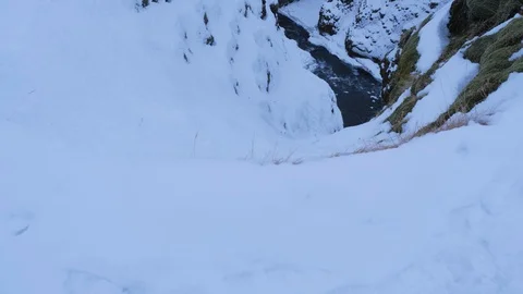 Iceland Winter View Of Large Snow Covered Valley With Rushing Water Below 1 Stock Footage 87489996