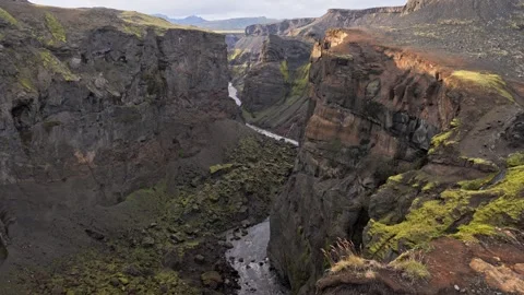 Icelandic canyon river cutting through steep volcanic cliffs with mossy textures Stock Footage 324887018